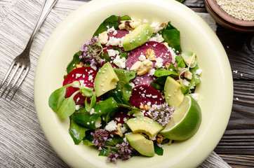 Top view at mediterranean roasted beet salad with avocado walnuts feta cheese oregano and mash...