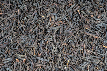 Black tea leaves background. Abstract food textures. Close up