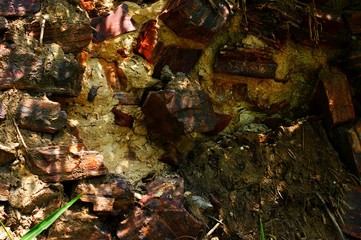 Old wall made of large stones of iron ore bonded by sand.