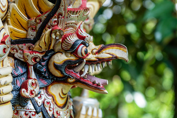 Balinese ancient colorful bird god Garuda with wings, closeup. Religious traditional statue from...