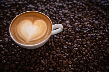 cup of coffee and coffee beans  on dark background, top view