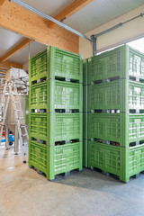 Green crates stacked on top of each other in an industrial building.