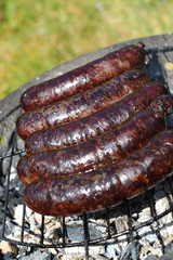 Grilling Blood Sausages on barbecue grill