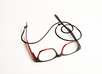 Stylish red eyeglasses with black cord on white background