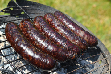 Grilling Blood Sausages on barbecue grill