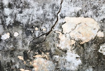 The old cement wall has cracks and peels, causing the pattern to look like an old man facing the side and smiling
