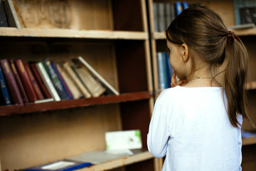 Little girl choosing books at street library