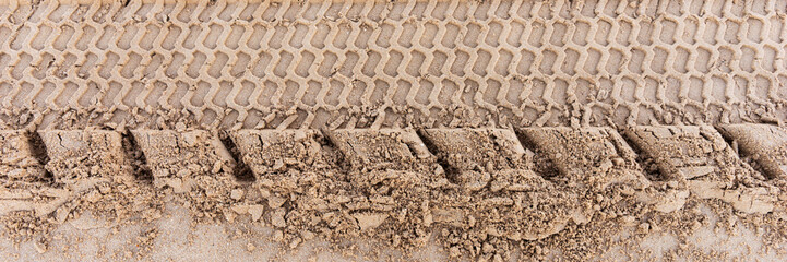 Tire track in the sand at the beach. Panoramic image