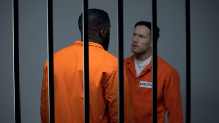 Afro-american and caucasian criminals quarreling in prison racial discrimination