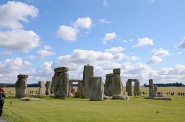 Fototapeta na wymiar STONEHENGE, WILTSHIRE, ENGLAND - AUGUST 19, 2014: Tourists visiting the world famous standing stones of Stonehenge in Wiltshire, England. Each standing stone is around 13 feet high.