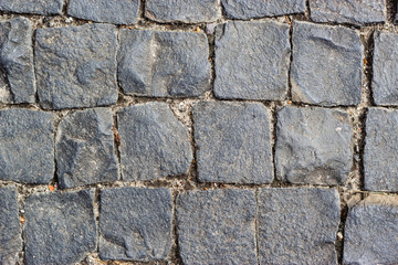 Texture of cobblestone in old town. Ancient gray pavement