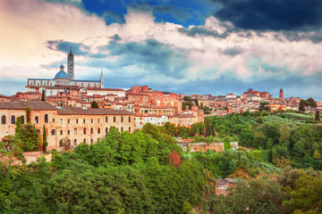 Fototapeta na wymiar Siena - amazing medieval town at sunset with view of the Dome & Bell Tower of Siena Cathedral (Duomo di Siena), landmark Mangia Tower and Basilica of San Domenico,Italy