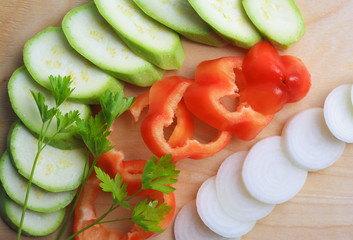 Cooking, cut vegetables on wooden board, red sweet pepper, zucchini, onion, parsley, vegetarian and vegan cuisine, diet, top view