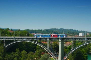 A tram runs over the bridge 'Kirchenfeldbrucke' in Bern, Switzerland on a summerday in 2019