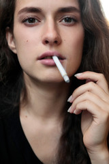 Closeup portrait of long haired curly beautiful girl. With cigarete .Smoking.