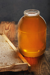 Fresh sweet honey in a large glass jar on a wooden table...