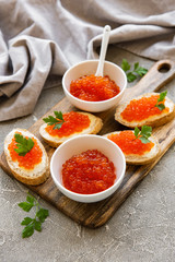 Red caviar in bowl and sandwiches