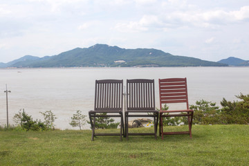 Naklejka na ściany i meble wooden chairs by the lake(river)