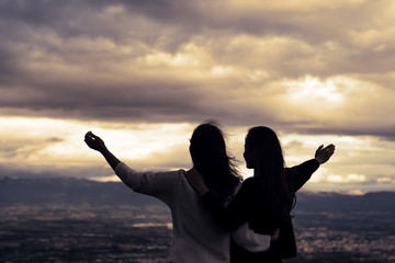 Christian worship and praise. Two young woman are praying and worshiping in the evening.