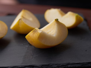 Slices of apple on stone plate on wooden table - breakfast with slices of apple - sliced golden apple