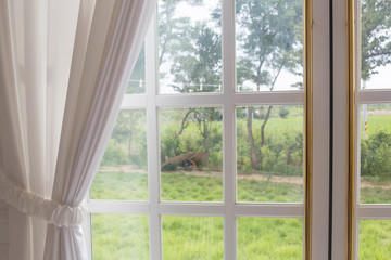 Fototapeta na wymiar White curtain and garden looking out the window