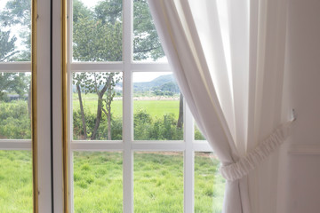 Fototapeta na wymiar White curtain and garden looking out the window