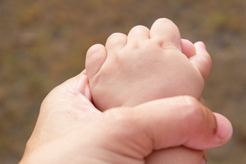 Hand baby in the hand of mother closeup
