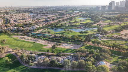 Golf course and Jumeirah lake towers skyscrapers before sunset timelapse,, Dubai, United Arab Emirates