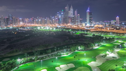 Fototapeta premium Wieżowce Dubai Marina i timelapse noc na polu golfowym, Dubaj, Zjednoczone Emiraty Arabskie