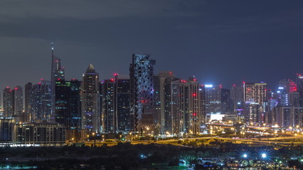Fototapeta na wymiar Jumeirah lake towers and Dubai marina skyscrapers and golf course during all night timelapse, Dubai, United Arab Emirates