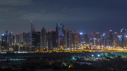 Fototapeta na wymiar Jumeirah lake towers and Dubai marina skyscrapers and golf course during all night timelapse, Dubai, United Arab Emirates