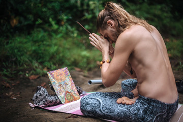Yoga practice and meditation in nature. Man practicing near river