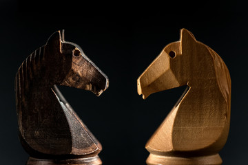 close view of white and black chess knights facing on blackground. © ThomasLENNE