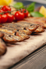 fish grill dish baked whole grilled on a plate with vegetables and lemon