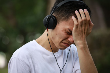 音楽を聴きながら泣く男性
