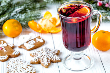 Christmas mulled wine with spices in cup on wooden background
