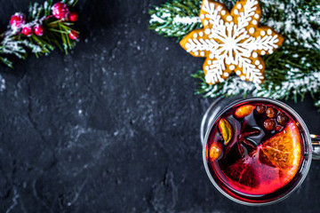 Obraz na płótnie Canvas Christmas mulled wine with spices in cup on dark background