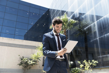 Low angle smiley man looking at tablet