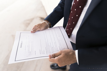 Close-up man in suit holding a contract