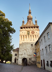 Naklejka premium Clock tower and old medieval architecture, in the citadel of the historic center of Sighisoara in Romania. Birthplace of Vlad Tepes, aka Dracula