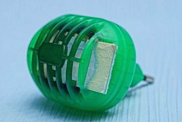 old green plastic fumigator lies on a blue table