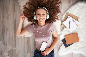 Portrait of smiling teenage girl listening to music