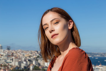 Beautiful girl with orange colored dress posing with Istanbul Scene