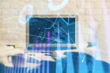 Stock market chart hologram drawn on personal computer background. Double exposure. Concept of investment.