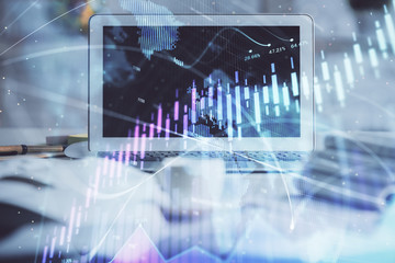 Stock market chart hologram drawn on personal computer background. Double exposure. Concept of investment.