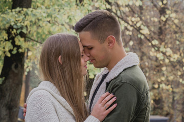 Fototapeta premium Happy couple in the autumn park have a fun time. Colored autumn