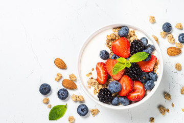 Greek yogurt granola with fresh berries on white table.