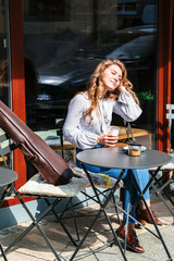 Girl dreams sitting with coffee and violin in cafe