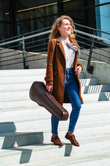 Girl with violin on stairs stairs looks at camera