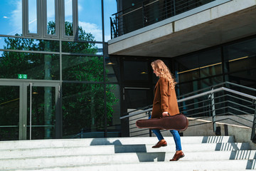 Woman with violin in case goes to lesson on stairs